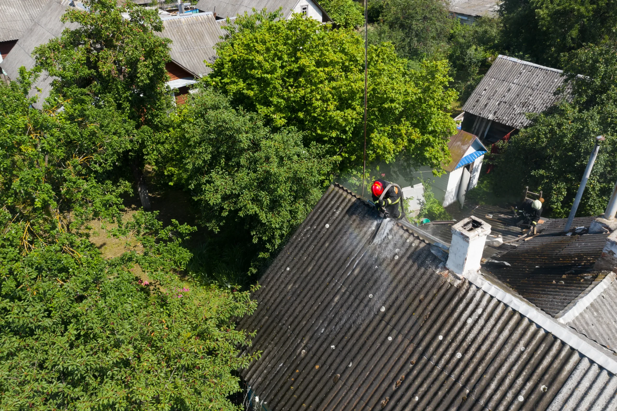 Firefighters extinguishing a fire on the roof of a residential home